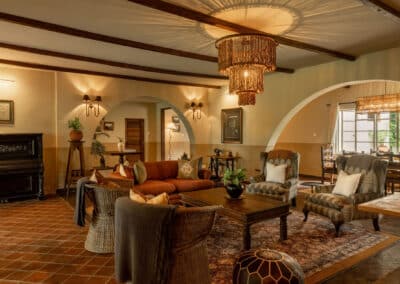 Farmhouse sitting room at Rivertrees Country Inn with cozy seating, chandelier lighting, and warm rustic decor